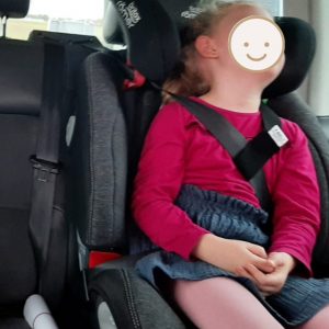 Mädchen schläft aufrecht in Kindersitz dank Y-BELT